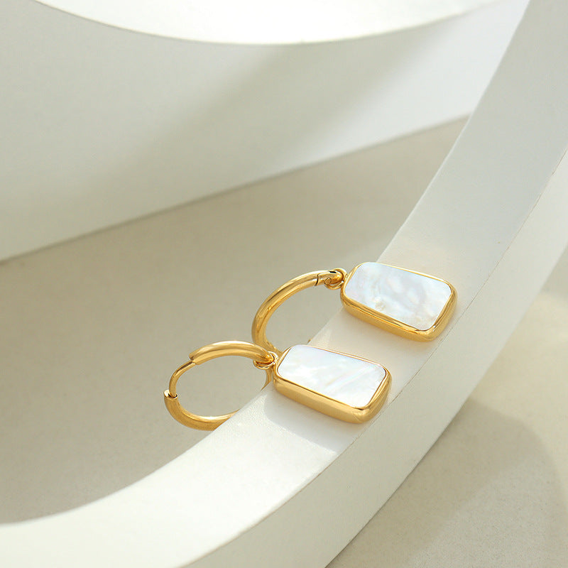 White Shell Hoops earrings by Nashira, shown close up
