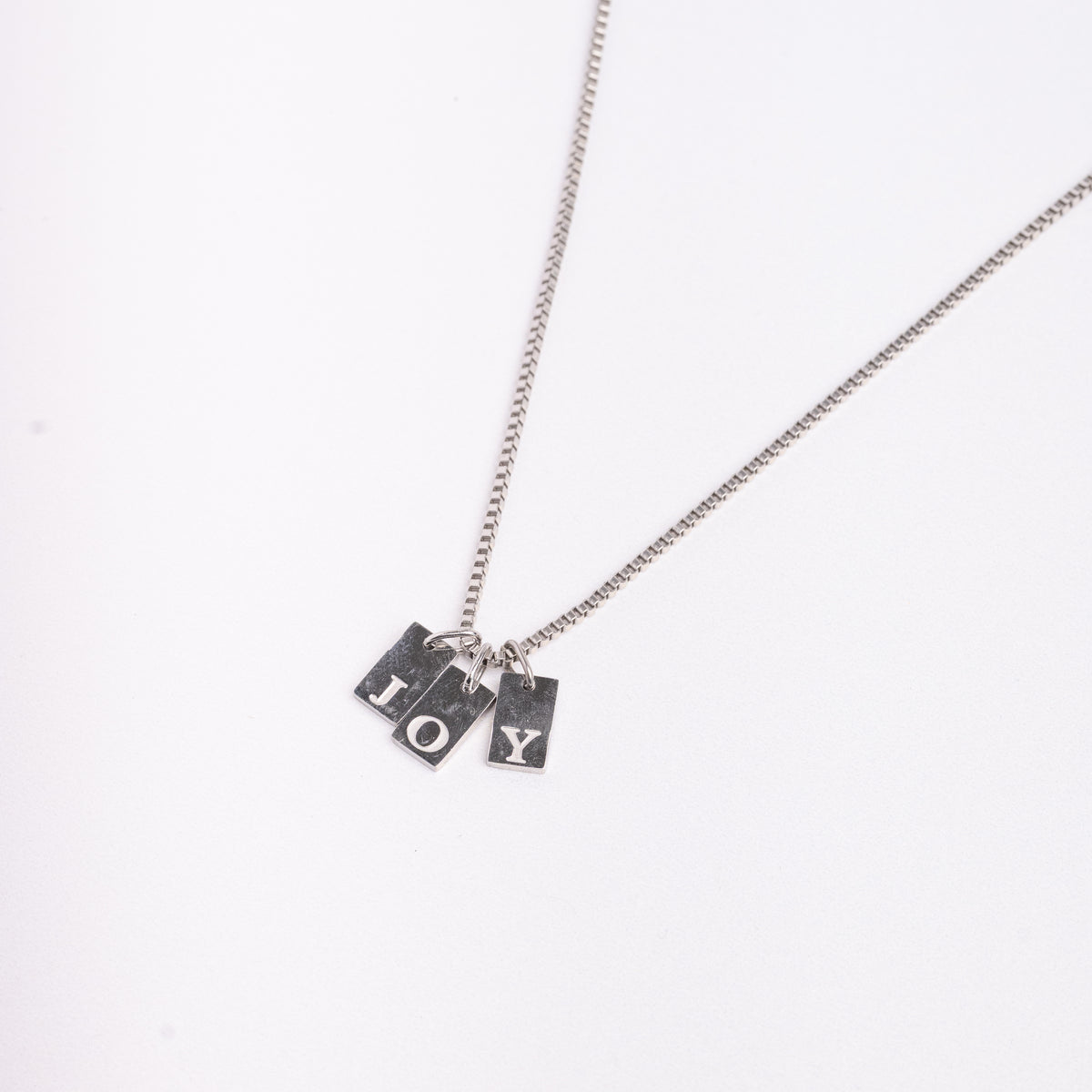 Dainty Alphabet String - Silver necklace by Nashira, shown close up